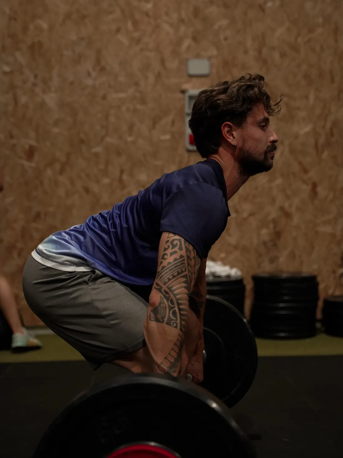 Atleta a levantar a barra do chão durante um treino
